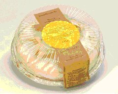This is the top view of a cake is in rigid plastic packaging. Although there are ridges along the side of the lid, there is a raised area that can support a label. The ridging on the sides can usually support a label.