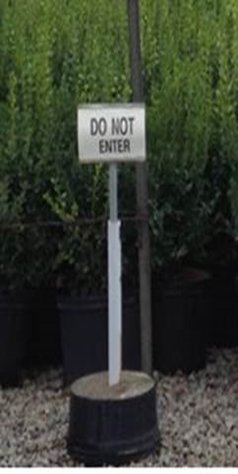 A sign that reads Do Not Enter in front of a production area of containerized plants.